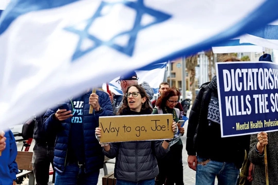 3月30日，位于以色列特拉维夫的美国驻以色列使馆前，一些民众挥舞以色列和美国国旗，表达对美国总统拜登的支持。此前拜登表示短期内不会邀请以色列总理内塔尼亚胡访问白宫，并警告以色列“不能继续”推动极具争议的司法改革。图/澎湃影像