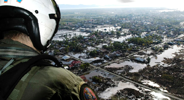 2004年海啸后，一架美国海军直升机在印度尼西亚苏门答腊岛上空飞行。