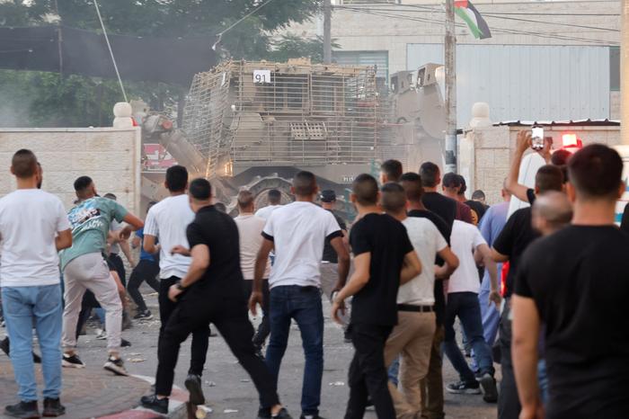 当地时间2023年7月3日，约旦河西岸杰宁，当地人们向以色列装甲车扔石块。