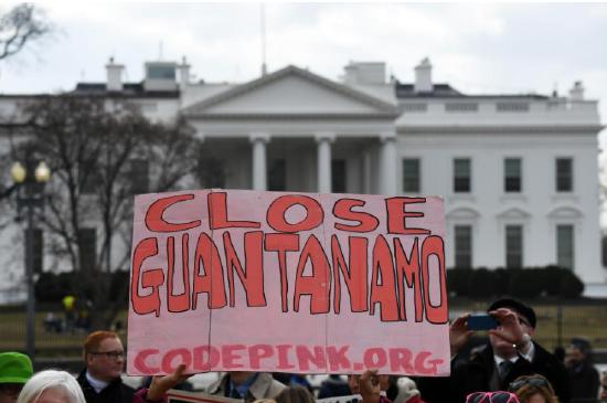 
                            2018年1月11日，人们在美国华盛顿白宫外参加抗议活动，要求关闭关塔那摩监狱。该监狱用以关押“9·11”事件后美军在全球反恐行动中抓获的嫌疑人，因多次传出虐囚丑闻而臭名昭著。新华社记者殷博古摄