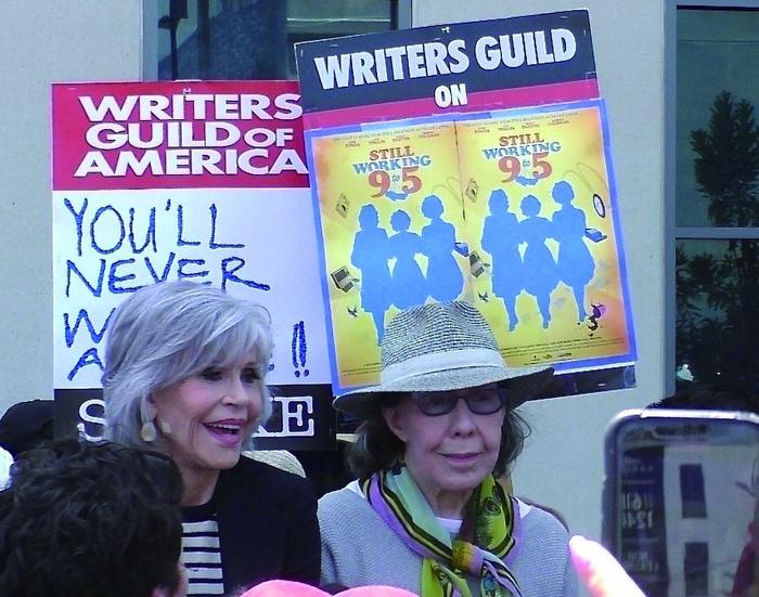 左图为好莱坞明星简·方达（左）和莉莉·汤姆林6月29日现身网飞公司外支持美国编剧协会罢工活动。（视觉中国）
