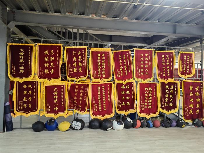 6月15日，陕西大黄蜂减肥营，训练场四周挂满锦旗。  新京报记者 刘思维 摄