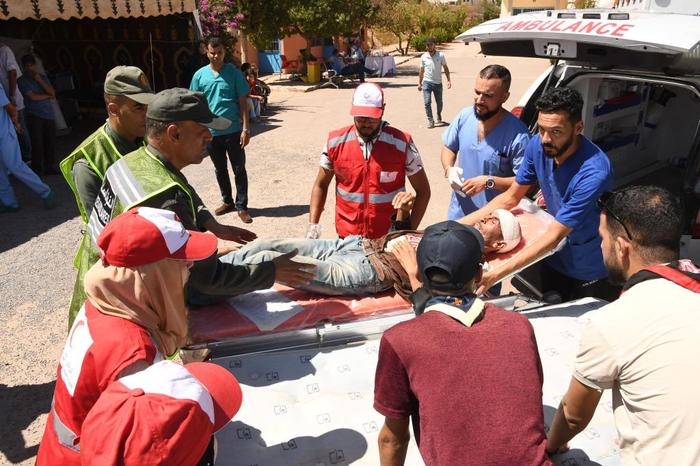 9月10日，在摩洛哥震中附近的艾兹鲁村，救援人员将伤者抬上救护车。新华社发（艾萨 摄）