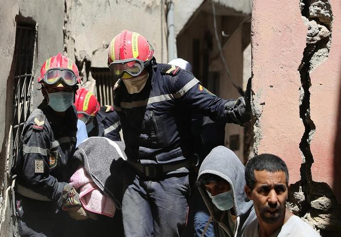 9月10日，在摩洛哥震中附近的艾米兹米兹村，救援人员在搜救工作中搬运一名遇难者的遗体。新华社记者 王东震 摄