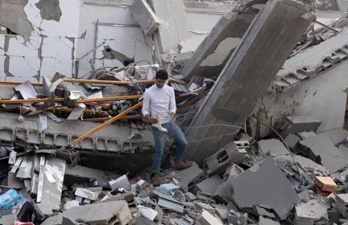 ·10月8日，加沙地带的巴勒斯坦人查看以色列空袭后的建筑废墟。（新华社发）