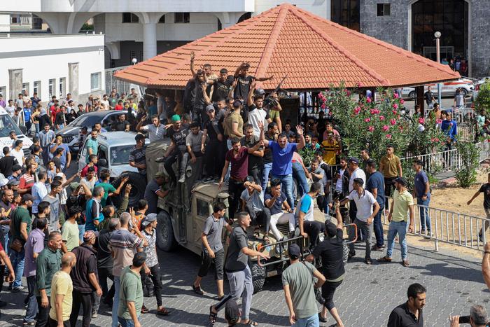 ▲10月7日，在加沙城，巴勒斯坦人登上一辆以色列军用车辆。图/新华社
