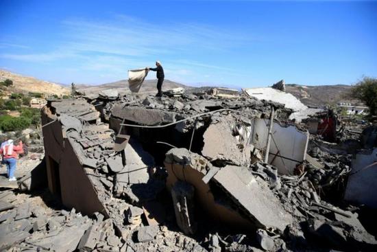 　10月21日，一名男子在黎巴嫩南部遭空袭损毁的房屋废墟上清理物品 图：新华社