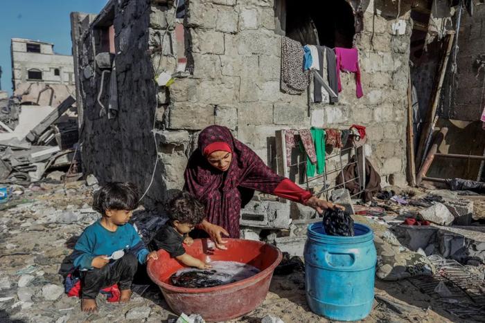 当地时间2023年11月4日，加沙地带，巴勒斯坦人正在废墟旁边洗衣服。图/IC photo