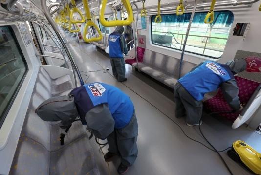 9日下午，首尔江西区首尔地铁9号线，防疫人员对地铁椅子进行高温蒸汽清洗及消毒。图源：韩媒