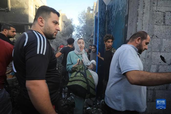 11月6日，人们从加沙地带中部地区一处被炸难民营逃离  图：新华社