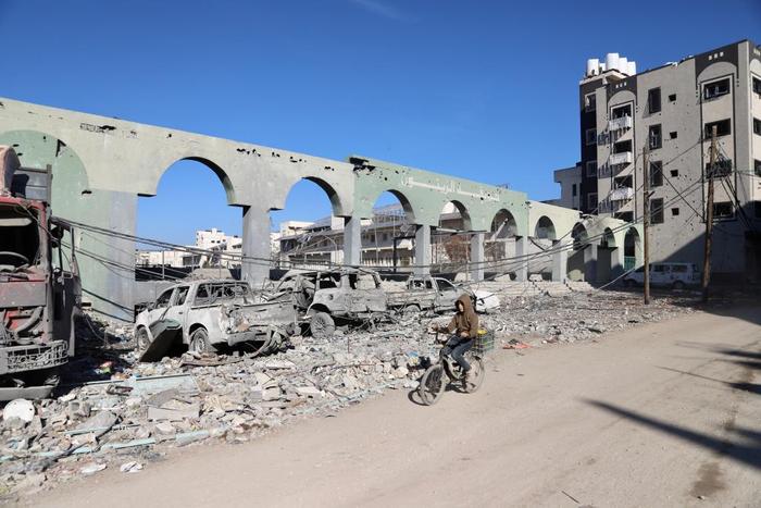 ▲1月7日，巴勒斯坦人骑车经过加沙城的建筑废墟。图/新华社