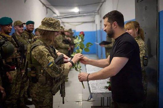 当地时间2023年9月4日，顿涅茨克地区，乌克兰总统弗拉基米尔·泽连斯基（右）在视察前线指挥所，并送女兵玫瑰花。
