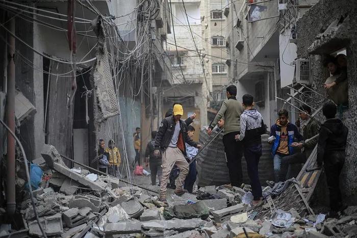 当地时间1月17日，加沙地带拉法，巴勒斯坦人检查他们在以色列袭击后被摧毁的家园。图源：视觉中国