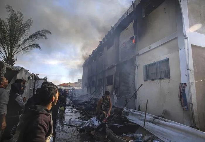 巴勒斯坦人试图扑灭近东救济工程处职业培训中心的大火。图源：视觉中国