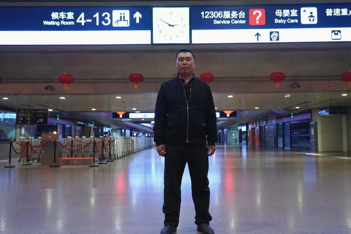 刘成在北京西站候车室拍照留念。  新京报记者 赵敏 摄