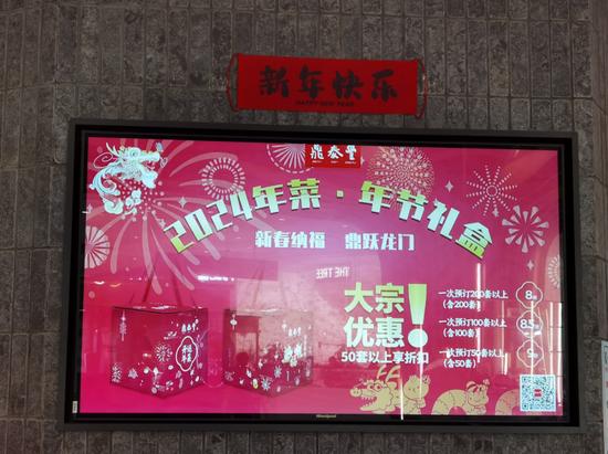  鼎泰丰北京世纪金源店门口电子屏的年夜饭礼盒广告。拍摄/陈烛