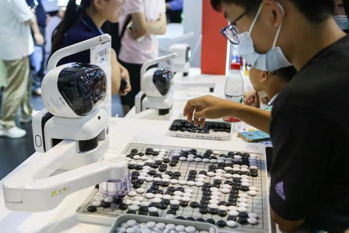 元萝卜AI下棋机器人与观众对弈。图片来源：新华社（记者：辛梦晨）